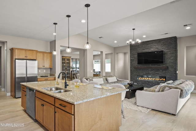 9129 Wild Skies Way, Reno, NV 89523 - kitchen with a sink, appliances with stainless steel finishes, open floor plan, light stone countertops, and a fireplace