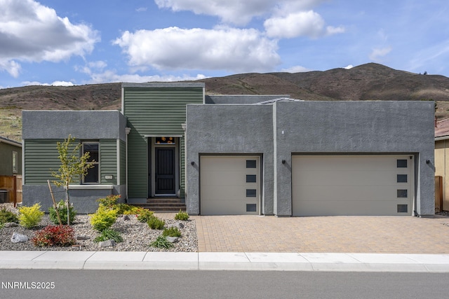 9129 Wild Skies Way, Reno, NV 89523 - modern home featuring an attached garage, decorative driveway, and a mountain view