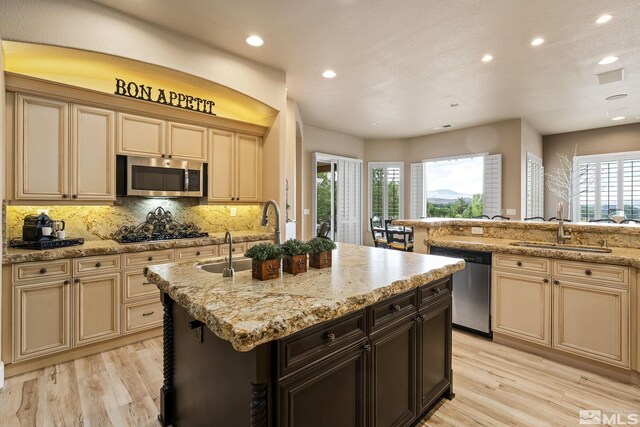 5330 Ventana Pkwy, Reno, NV 89511 - kitchen featuring stainless steel appliances, cream cabinets, a sink, recessed lighting, and light wood finished floors