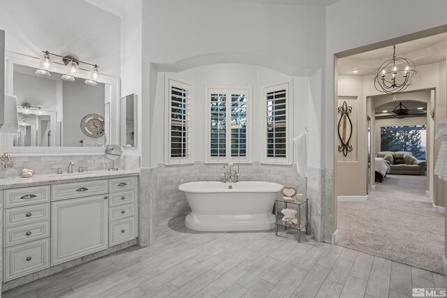 5330 Ventana Pkwy, Reno, NV 89511 - ensuite bathroom with ceiling fan, tile walls, a soaking tub, wood finished floors, and vanity