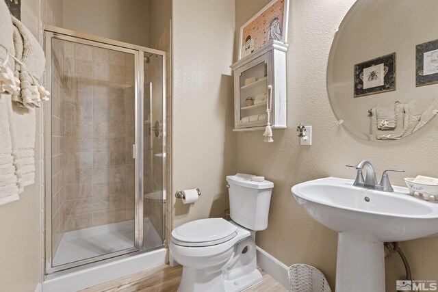 5330 Ventana Pkwy, Reno, NV 89511 - bathroom featuring a shower stall, toilet, wood finished floors, a sink, and baseboards