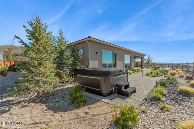 9220 Wild Skies Ct, Reno, NV 89523 - rear view of property with a hot tub, a patio, and stucco siding