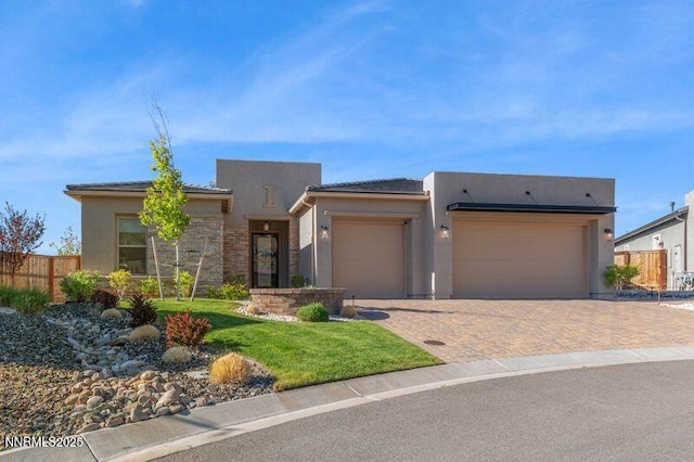 9220 Wild Skies Ct, Reno, NV 89523 - view of front of home featuring stucco siding, an attached garage, driveway, and stone siding