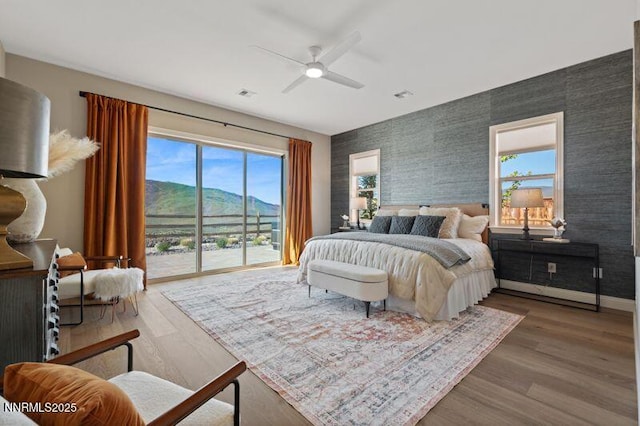 9220 Wild Skies Ct, Reno, NV 89523 - bedroom featuring access to exterior, wood finished floors, ceiling fan, a mountain view, and baseboards