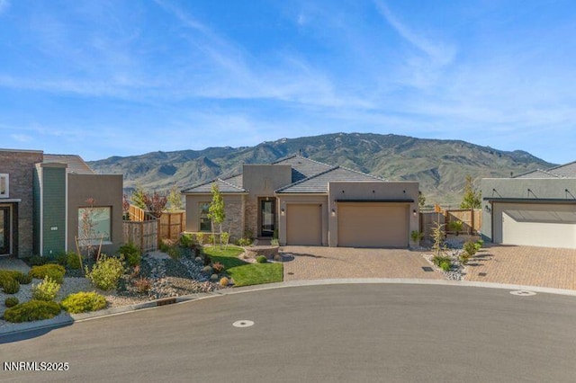 9220 Wild Skies Ct, Reno, NV 89523 - pueblo-style home with a mountain view, a garage, stucco siding, and decorative driveway