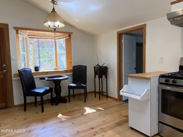 1303 N Division St, Carson City, NV 89703 - kitchen featuring gas stove, lofted ceiling, light wood-style flooring, range hood, and decorative light fixtures