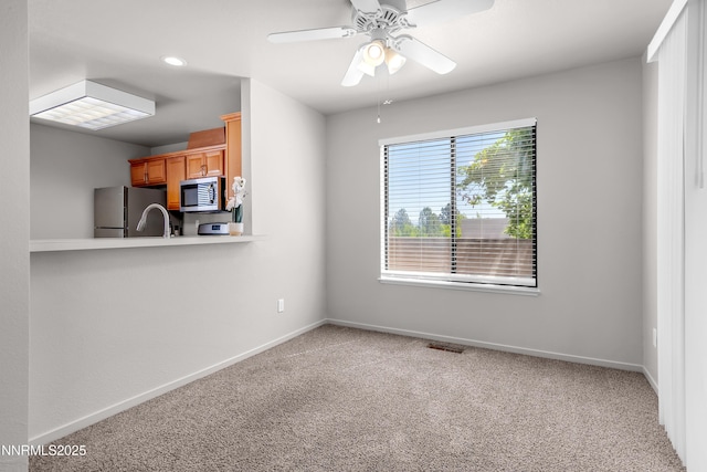 1970 Sierra Highlands Dr, Reno, NV 89523 - kitchen with stainless steel appliances, carpet, baseboards, light countertops, and ceiling fan