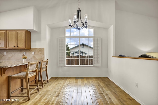 1458 Rosy Finch Dr, Sparks, NV 89441 - dining room featuring a chandelier, light wood-type flooring, lofted ceiling, and baseboards