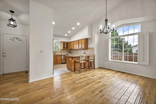 1458 Rosy Finch Dr, Sparks, NV 89441 - kitchen featuring stainless steel dishwasher, brown cabinetry, a chandelier, light wood-style flooring, and glass insert cabinets