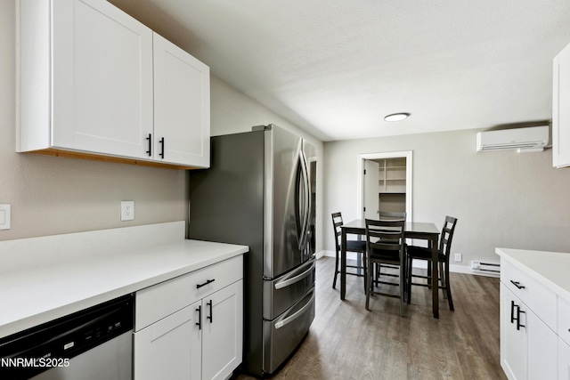 495 Margrave Dr, Reno, NV 89502 - kitchen with appliances with stainless steel finishes, an AC wall unit, a baseboard radiator, dark wood-style flooring, and white cabinets