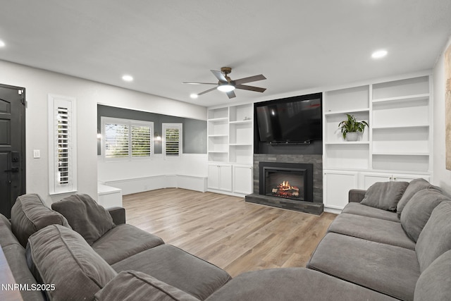 14690 Rancheros Dr, Reno, NV 89521 - living area featuring ceiling fan, recessed lighting, a lit fireplace, and light wood-style flooring