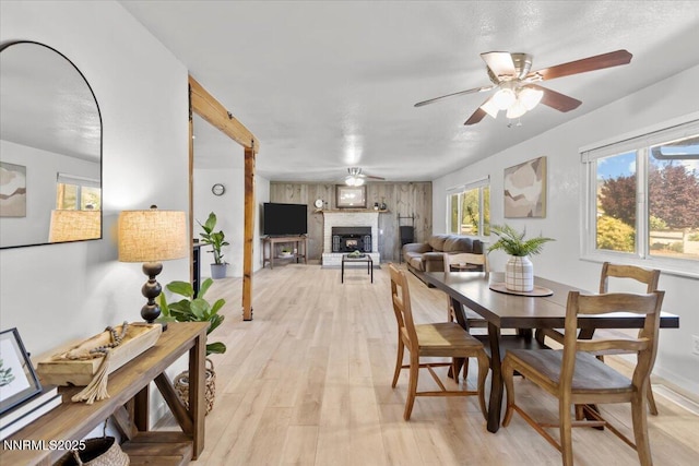 1235 Koontz Ln, Carson City, NV 89701 - dining space featuring a fireplace with raised hearth, light wood-style floors, and a ceiling fan