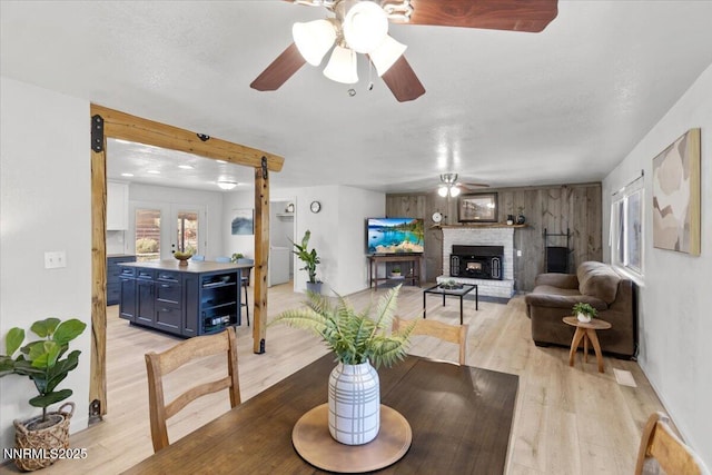 1235 Koontz Ln, Carson City, NV 89701 - dining area featuring ceiling fan, light wood-style floors, a fireplace, and baseboards