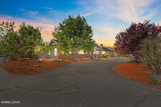 1235 Koontz Ln, Carson City, NV 89701 - view of property hidden behind natural elements with curved driveway and stucco siding