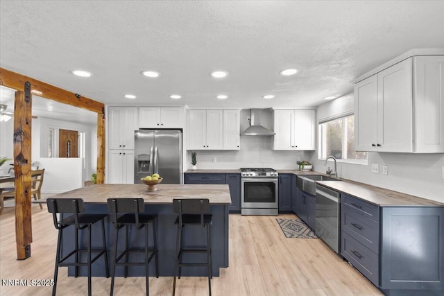 1235 Koontz Ln, Carson City, NV 89701 - kitchen with stainless steel appliances, wall chimney exhaust hood, a sink, recessed lighting, and white cabinetry