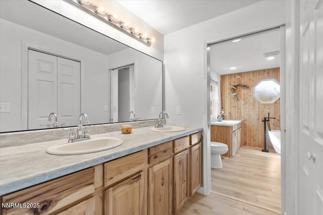 1235 Koontz Ln, Carson City, NV 89701 - full bathroom with toilet, double vanity, a tub, wood finished floors, and wooden walls