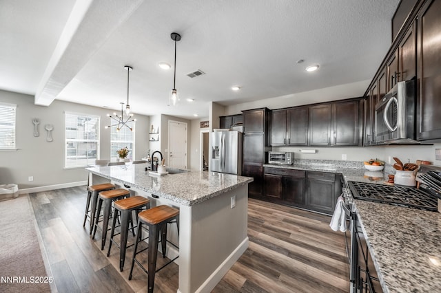 1845 Sea Horse Rd Unit C, Reno, NV 89521 - kitchen with stainless steel appliances, dark brown cabinets, dark wood-type flooring, a kitchen island with sink, and a kitchen breakfast bar