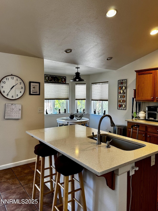 1332 Brooke Way, Gardnerville, NV 89410 - kitchen with a kitchen bar, a sink, dark tile patterned floors, recessed lighting, and an island with sink