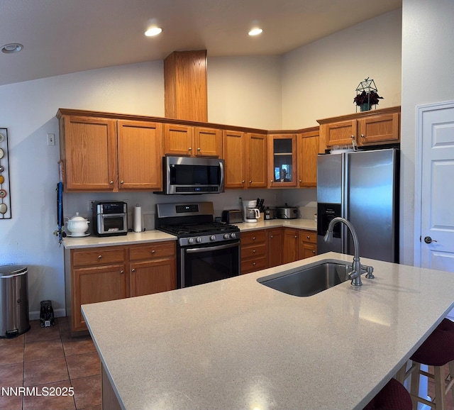 1332 Brooke Way, Gardnerville, NV 89410 - kitchen featuring appliances with stainless steel finishes, a sink, brown cabinetry, a kitchen island with sink, and light countertops