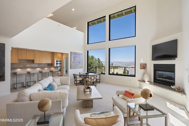 2260 Stone Mountain Cir, Reno, NV 89519 - living room featuring a towering ceiling, carpet floors, baseboards, a glass covered fireplace, and recessed lighting