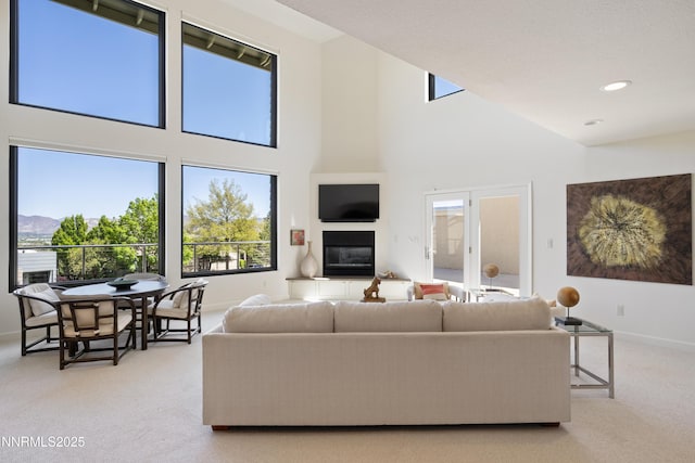 2260 Stone Mountain Cir, Reno, NV 89519 - carpeted living room featuring healthy amount of natural light, a towering ceiling, a fireplace, baseboards, and recessed lighting