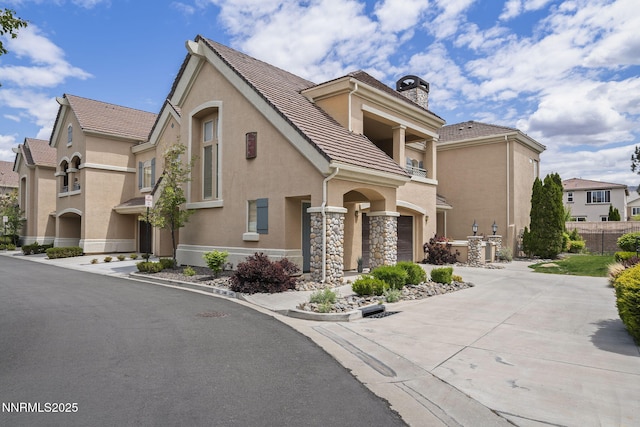 9900 Wilbur May Pkwy Unit 2406, Reno, NV 89521 - view of front of property featuring a balcony, stucco siding, a chimney, concrete driveway, and an attached garage