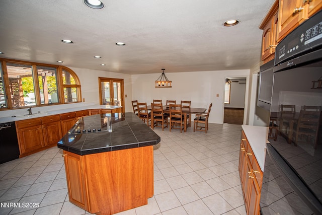 9100 Wigwam Way, Reno, NV 89506 - kitchen with brown cabinetry, a kitchen island, recessed lighting, black appliances, and light tile patterned flooring
