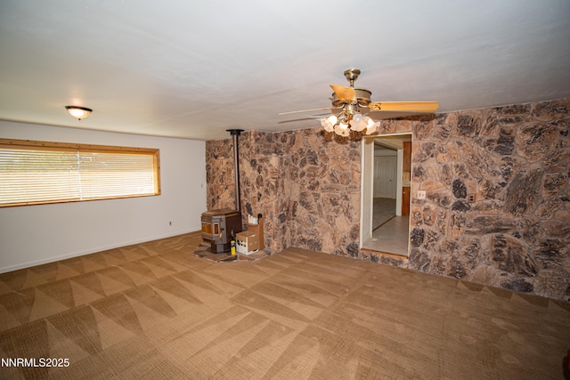 9100 Wigwam Way, Reno, NV 89506 - unfurnished living room featuring a wood stove, ceiling fan, carpet, and baseboards