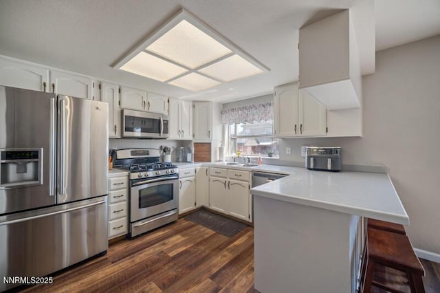 1061 Aimee Ln, Fallon, NV 89406 - kitchen featuring stainless steel appliances, a peninsula, white cabinets, and dark wood finished floors
