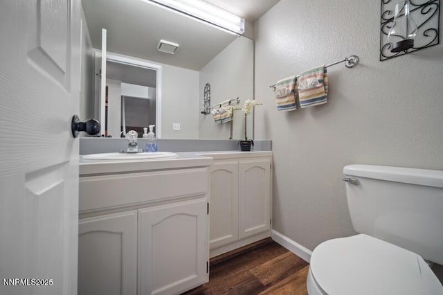 1061 Aimee Ln, Fallon, NV 89406 - half bath with vanity, toilet, wood finished floors, and baseboards