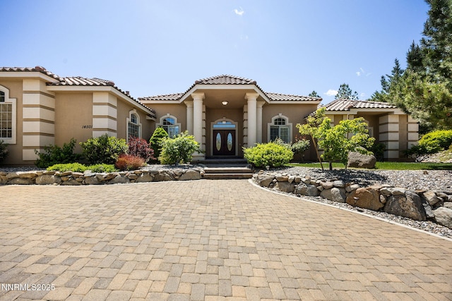 14501 Quail Rock Ct, Reno, NV 89511 - mediterranean / spanish-style house featuring curved driveway, stucco siding, and a tiled roof