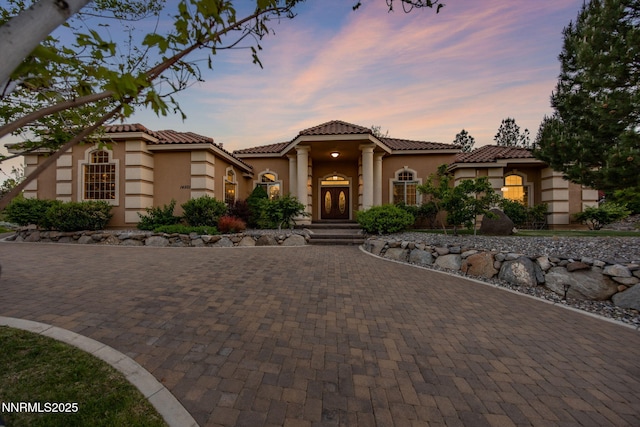 14501 Quail Rock Ct, Reno, NV 89511 - mediterranean / spanish-style house featuring stucco siding, curved driveway, and a tile roof
