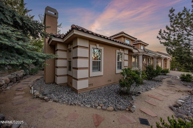 14501 Quail Rock Ct, Reno, NV 89511 - view of side of property with a chimney, stucco siding, and a tile roof