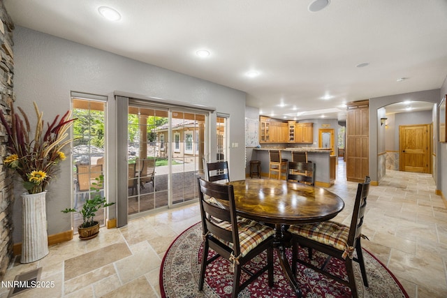14501 Quail Rock Ct, Reno, NV 89511 - dining room with arched walkways, stone tile flooring, baseboards, recessed lighting, and decorative columns