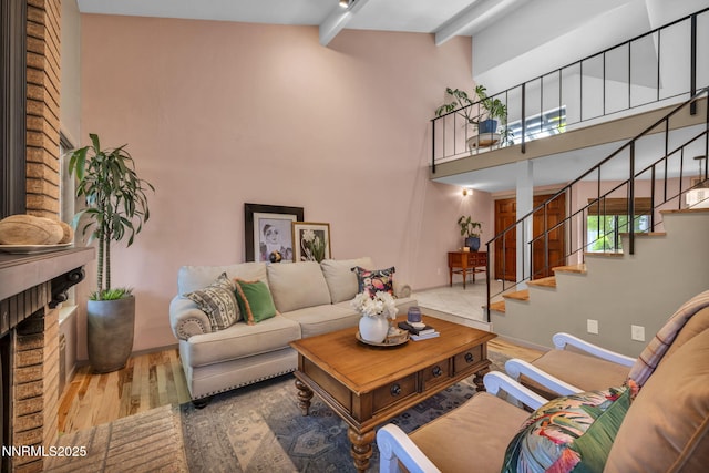 4307 Clyde Ct, Reno, NV 89509 - living area featuring stairs, wood finished floors, beam ceiling, a towering ceiling, and baseboards