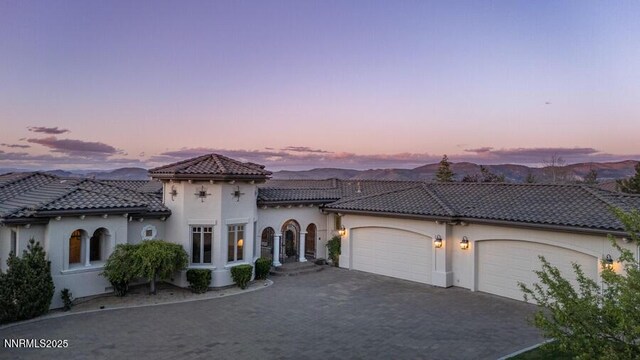 14200 Wild Quail Ct, Reno, NV 89511 - mediterranean / spanish-style house featuring asphalt driveway, a tiled roof, a garage, and stucco siding