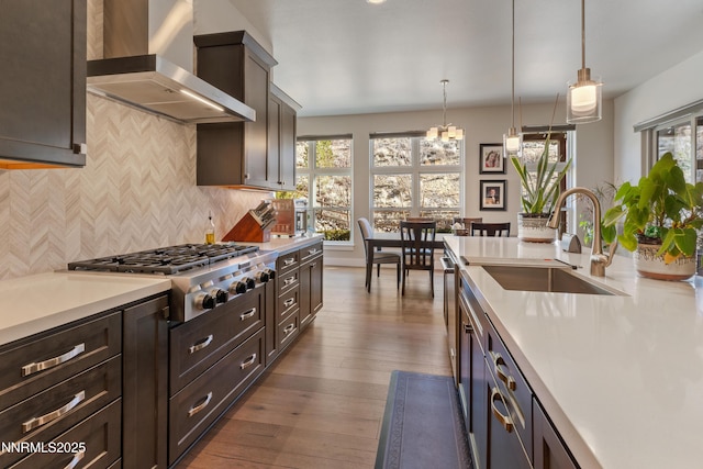 4069 Whispering Pine Loop, Reno, NV 89519 - kitchen featuring wall chimney range hood, stainless steel gas stovetop, a sink, light countertops, and healthy amount of natural light