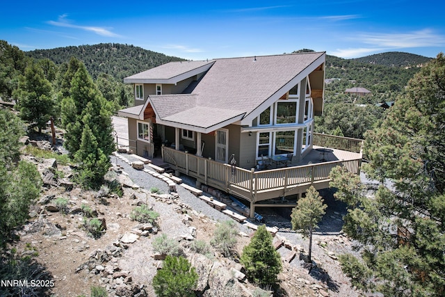 2140 Conestoga Rd, Reno, NV 89521 - rear view of property with a deck with mountain view, a shingled roof, and a forest view