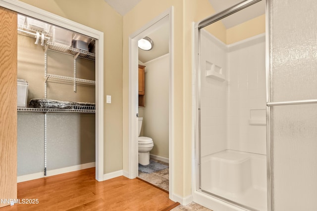 2140 Conestoga Rd, Reno, NV 89521 - bathroom featuring a shower stall, wood finished floors, toilet, and baseboards