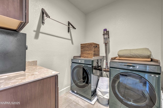 2028 Whitecliff Dr, Reno, NV 89521 - laundry area with cabinet space, washer and dryer, a textured wall, light tile patterned floors, and baseboards
