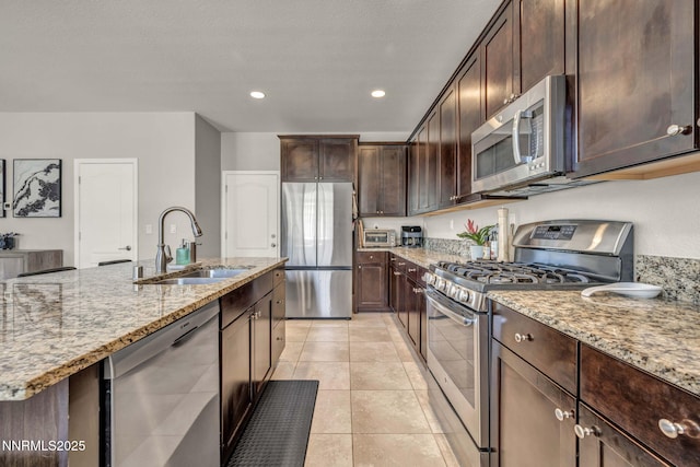2028 Whitecliff Dr, Reno, NV 89521 - kitchen featuring appliances with stainless steel finishes, a sink, light stone counters, dark brown cabinets, and recessed lighting