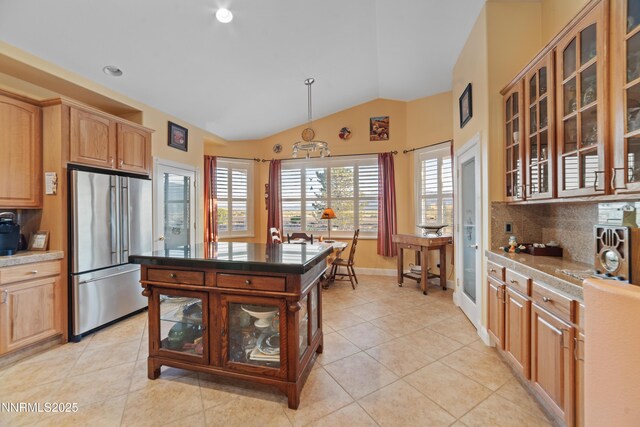 1184 Stephanie Way, Minden, NV 89423 - kitchen with high end fridge, vaulted ceiling, decorative backsplash, light tile patterned floors, and glass insert cabinets