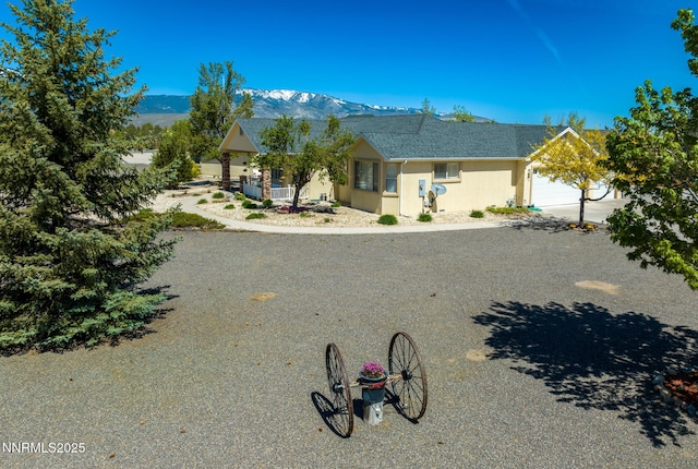 1184 Stephanie Way, Minden, NV 89423 - view of front facade featuring a mountain view, a shingled roof, an attached garage, and stucco siding