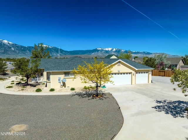 1184 Stephanie Way, Minden, NV 89423 - ranch-style house with a mountain view, a garage, concrete driveway, and stucco siding