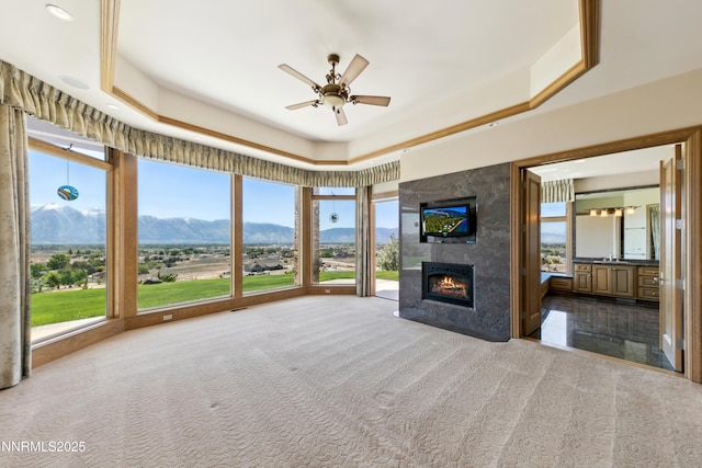 1103 Cortez Ln, Gardnerville, NV 89410 - unfurnished living room with a tray ceiling, carpet, a ceiling fan, and a fireplace