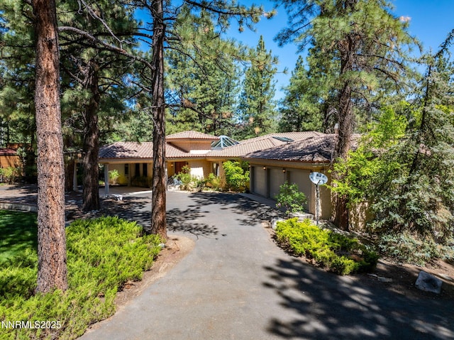 390 Sylvan Ct, Verdi, NV 89439 - view of front facade featuring a tiled roof, asphalt driveway, a garage, and stucco siding