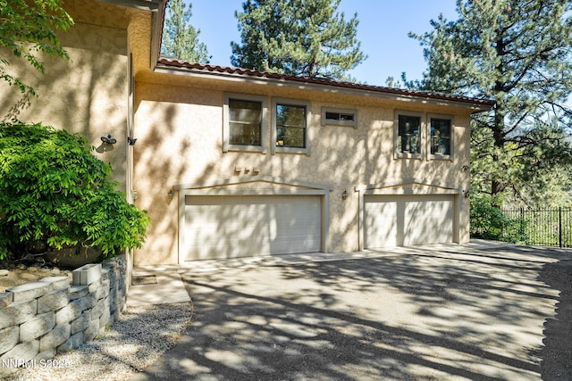 390 Sylvan Ct, Verdi, NV 89439 - view of side of property with stucco siding, an attached garage, driveway, and a tiled roof