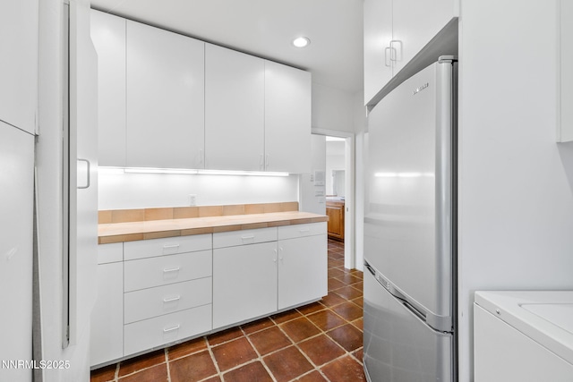 390 Sylvan Ct, Verdi, NV 89439 - kitchen with freestanding refrigerator, washing machine and clothes dryer, white cabinets, recessed lighting, and dark tile patterned flooring