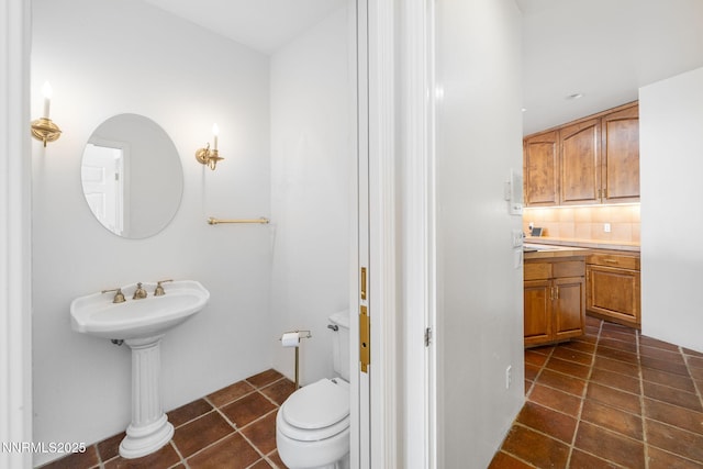 390 Sylvan Ct, Verdi, NV 89439 - bathroom featuring toilet, backsplash, a sink, and tile patterned flooring