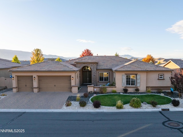 9845 Sea Breeze Ln, Reno, NV 89521 - view of front of home featuring stucco siding, a garage, a front yard, and decorative driveway